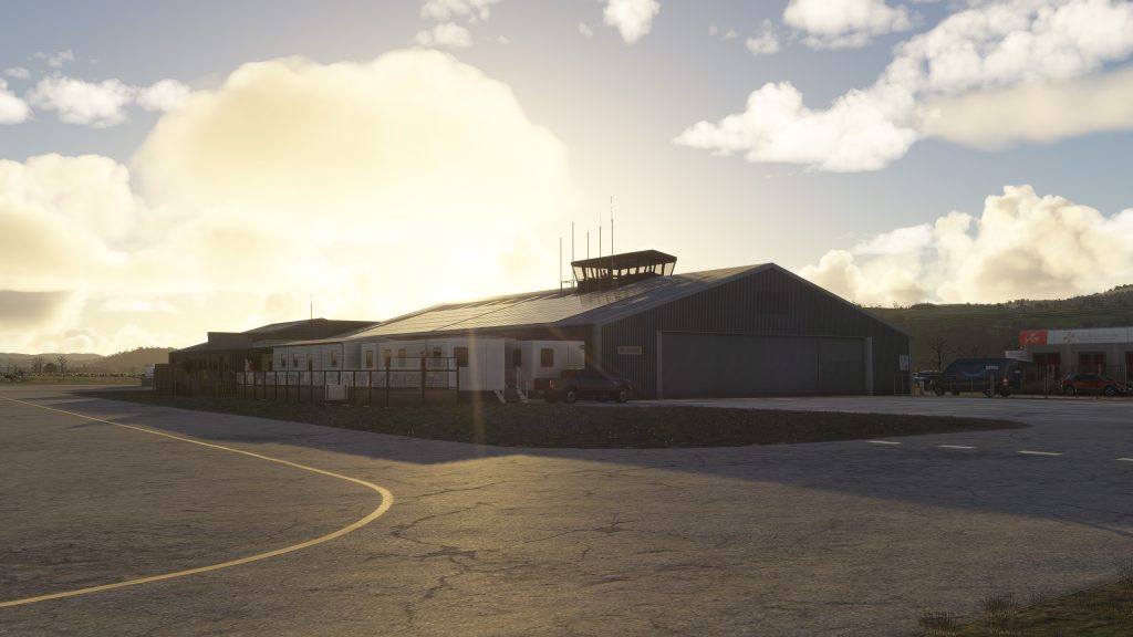 Aéroport Welshpool de Burning Blue Design pour MSFS 2020 et MSFS 2024, belle vue sur le coucher du soleil sur le hangar principal et la tour de contrôle.