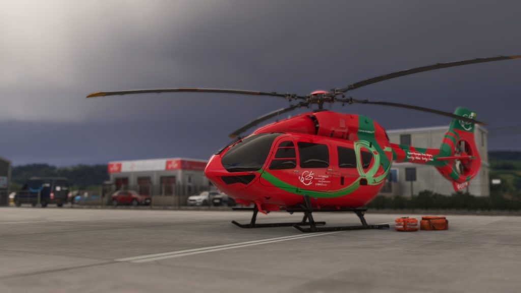 Aéroport Welshpool de Burning Blue Design pour MSFS 2020 et MSFS 2024, Vue INSIM de l'ambulance Welsh Air EC-145 Helicpoter sur le tablier avec des sacs EMT prêts à se charger.