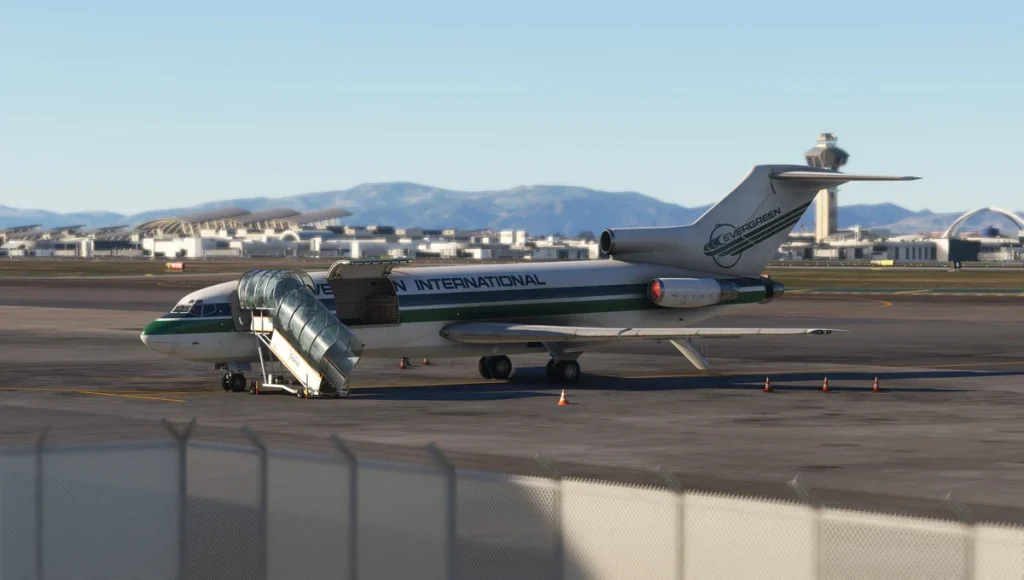 Evergreen International Boeing 727 stationné sur le tarmac de l'aéroport avec escalier mobile et terminaux en arrière-plan