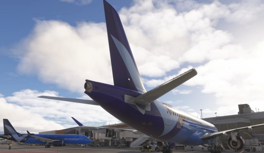 Vue arrière du Synaptic A220-300 aux côtés des avions Breeze Airways au terminal.